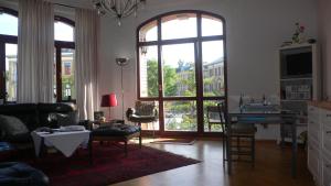 a living room with a large window and a table and chairs at Ferienwohnung Villa Fiedler in Dresden