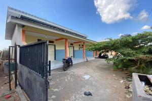 ein Haus mit einem Motorrad, das draußen geparkt ist in der Unterkunft OYO Life 93156 Rumah Kosan in Tanjung