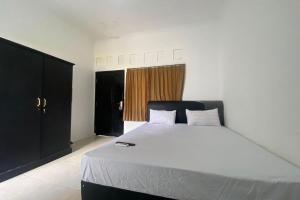 een slaapkamer met een groot wit bed in een kamer bij OYO Life 93156 Rumah Kosan in Tanjung