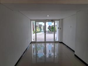 ein leerer Flur mit offener Tür zu einem Haus in der Unterkunft OYO Life 93140 Apartment Grand Sentraland By Fahri in Jaken 1