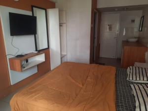 a bedroom with a bed and a flat screen tv at OYO Life 93140 Apartment Grand Sentraland By Fahri in Jaken 1