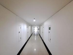 einen leeren Flur in einem Gebäude mit weißen Wänden in der Unterkunft OYO Life 93140 Apartment Grand Sentraland By Fahri in Jaken 1
