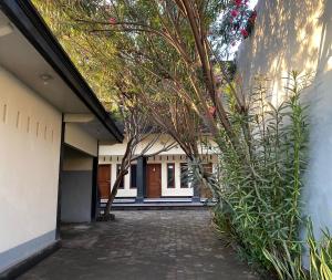 a courtyard of a house with trees and a building at OYO Life 93155 Wisma Sarah in Tanjung