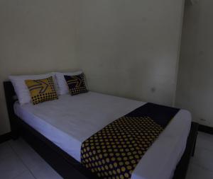 a small bed in a room with pillows on it at OYO Life 93155 Wisma Sarah in Tanjung