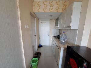 a small kitchen with a bottle of water on the counter at OYO Life 93106 Apartement Grand Sentraland By Andi in Karawang