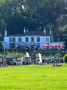 a large white building with people sitting in the grass at Garden Place in Clevedon