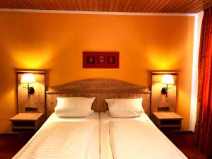 a bedroom with a large bed with two pillows at Hotel Paintner in Germering