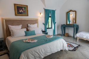 een slaapkamer met een groot bed met twee gerechten erop bij Dar Gino in Kelibia