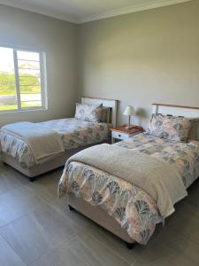 1 dormitorio con 2 camas y ventana en Silwer, en Struisbaai