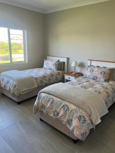 a bedroom with two beds and a window at Silwer in Struisbaai