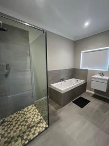 a bathroom with a shower and a tub and a sink at Silwer in Struisbaai +27 photos