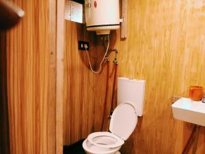 a bathroom with a white toilet in a wooden wall at B ,heritage luxury houseboat in Srinagar