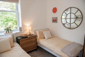 a bedroom with two beds and a mirror on the wall at Seaward in Lyme Regis