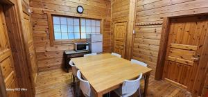 comedor de madera con mesa y nevera en まちなかlodge ほしとたきび Lodge in city Hoshi to Takibi, en Ōmuta