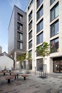 een weergave van een gebouw met banken ervoor bij Coleman Court Summer Apartments in Cork