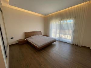 ein Schlafzimmer mit einem Bett und einem großen Fenster in der Unterkunft İkiz evler in Cesme