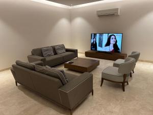 sala de estar con 2 sofás y TV de pantalla plana en İkiz evler, en Cesme