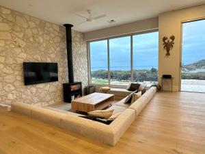 un soggiorno con divano e TV di Middle River Vista Beach House a Stokes Bay
