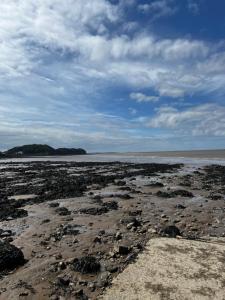 a beach with rocks and the ocean on a cloudy day at Garden Place in Clevedon