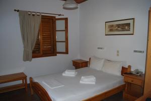 ein Schlafzimmer mit einem weißen Bett und einem Fenster in der Unterkunft Siroco's Rooms And Studios in Parikia