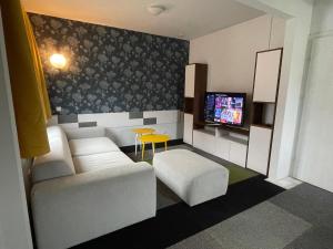 a living room with a white couch and a tv at Komarowo77 