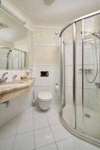 a white bathroom with a shower and a toilet at Woźniak Residence in Karpacz