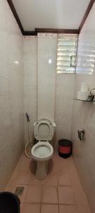 a small bathroom with a toilet in a stall at La Vida Hostel in Puerto Princesa City