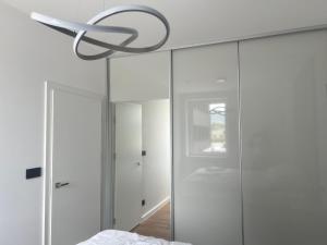 a bedroom with white walls and a chandelier at Apartmány Ambiente in Kľušov +85 photos
