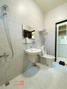 y baño con lavabo, aseo y ducha. en Unique Homestay en Tainan