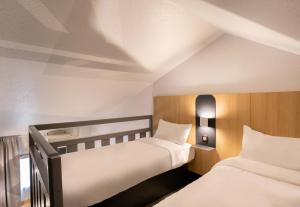a bedroom with two beds and a window at B&B HOTEL Lorient Lanester in Lanester