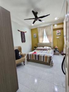 a bedroom with a bed and a ceiling fan at The Bungalow Homestay with Private Pool by Cheta in Alor Setar +8 photos