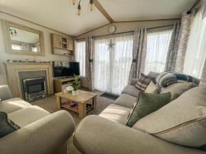 a living room with two couches and a fireplace at Spacious Caravan With Large Decking Area, Perfect To Enjoy The Sun, Ref 23058c in Hunstanton