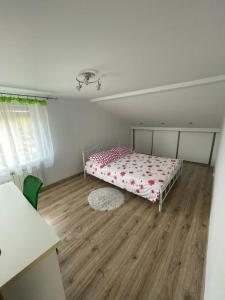 um quarto com uma cama e piso em madeira em ,,Dom na Wzgórzach,, em Bachowice