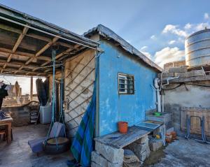 een blauw huis met een bankje ervoor bij Meow! Marcia Youth Hostel in Pingtan