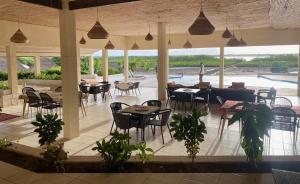 a restaurant with tables and chairs and a patio at Toubacouta Lodges in Toubakouta