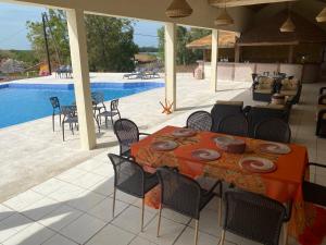 un patio con mesa y sillas junto a una piscina en Toubacouta Lodges, en Toubakouta