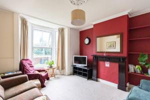 uma sala de estar com uma parede vermelha em Park View House - Sleeps 6 em York