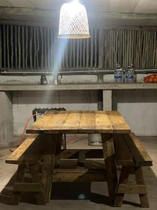 a wooden picnic table with a light above it at Mantekuview Homestay 