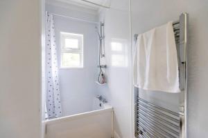 y baño blanco con bañera y ducha. en Park View House - Sleeps 6, en York