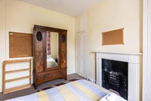 a bedroom with a bed and a dresser and a fireplace at Park View House - Sleeps 6 in York