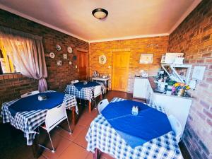 una sala da pranzo con 2 tavoli e una cucina di Villa Mosaiko a Kathu
