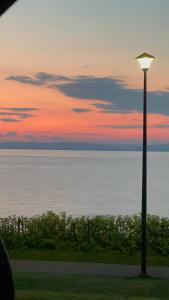 a street light in front of the ocean at sunset at Garden Place in Clevedon