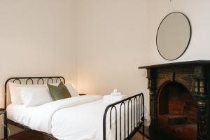 een slaapkamer met een bed met een spiegel aan de muur bij Luxurious terrace home in heart of town in Bendigo