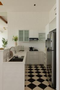 una cocina blanca con suelo a cuadros en blanco y negro en La Meira Estate en Vagator