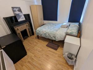 a small bedroom with a bed and a fireplace at RAHAL HACKNEY in London