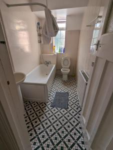 a bathroom with a tub sink and a toilet at RAHAL HACKNEY in London