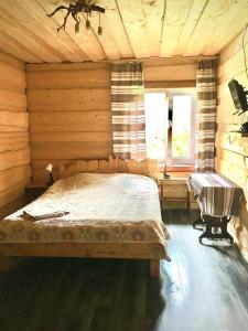 a bedroom with a bed in a wooden cabin at Котедж Шум Черемоша на березі річки in Verkhovyna