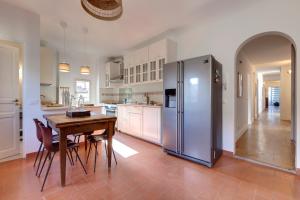 a kitchen with a table and a stainless steel refrigerator at Mamo Florence - Il Prato Apartment in Florence