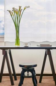 a table with a vase of flowers and a stool at InterContinental Genève by IHG in Geneva