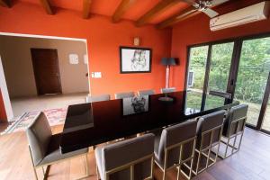 uma sala de jantar com paredes cor de laranja e uma mesa e cadeiras em villa 1314 em Kasauli